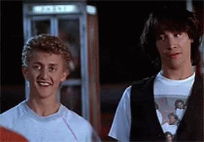 Two Men Are Standing Next To Each Other In Front Of A Phone Booth . GIF