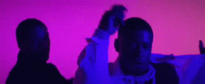 Two Men Are Standing Next To Each Other In Front Of A Purple And Pink Background . GIF