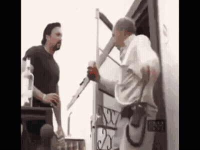Two Men Are Standing Next To Each Other In Front Of A Trailer . GIF