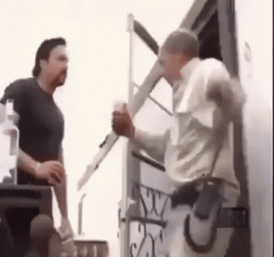 Two Men Are Standing Next To Each Other In Front Of A Trailer . GIF