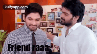 Two Men Are Standing Next To Each Other In Front Of A Wall . GIF
