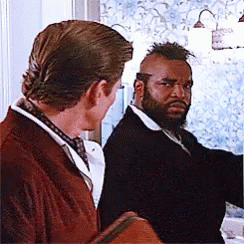 Two Men Are Standing Next To Each Other In Front Of A Window . One Has A Beard And The Other Has A Mohawk . GIF