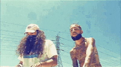 Two Men Are Standing Next To Each Other In Front Of Power Lines GIF