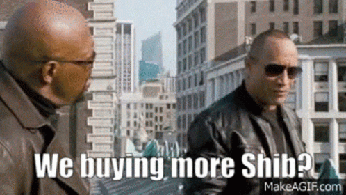 Two Men Are Standing Next To Each Other On A City Street And One Of Them Is Asking The Other If He Is Buying More Shiba  GIF