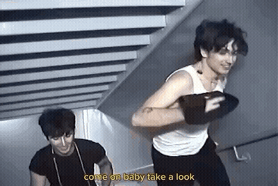 Two Men Are Standing Next To Each Other On A Set Of Stairs And One Of Them Is Holding A Boxing Glove . GIF