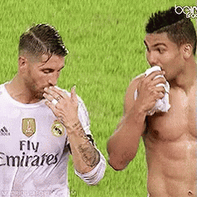 Two Men Are Standing Next To Each Other On A Soccer Field And One Of Them Is Wearing A Fly Emirates Shirt . GIF