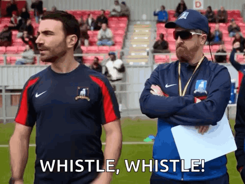 Two Men Are Standing Next To Each Other On A Soccer Field . GIF