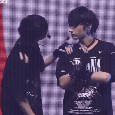 Two Men Are Standing Next To Each Other On A Stage . GIF