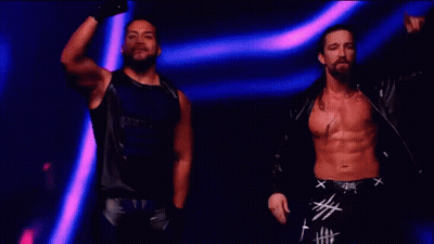 Two Men Are Standing Next To Each Other On A Stage . GIF