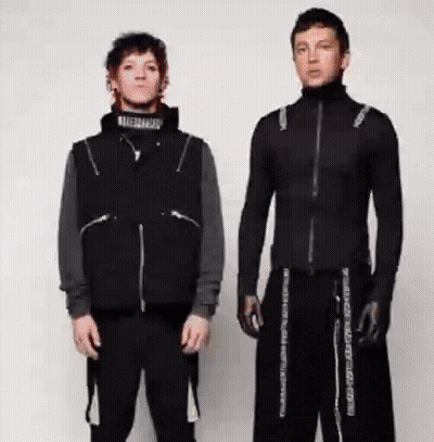 Two Men Are Standing Next To Each Other Wearing Black Clothes And Gloves . GIF