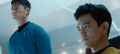 Two Men Are Standing Next To Each Other With One Wearing A Blue Shirt With The Letter A On It GIF
