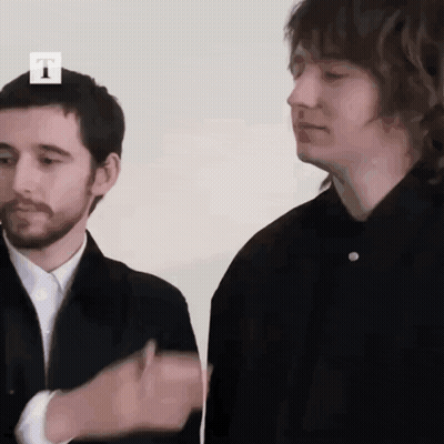 Two Men Are Standing Next To Each Other With The Letter T On The Top GIF
