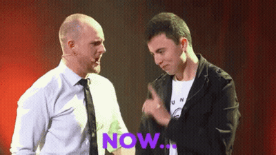 Two Men Are Standing Next To Each Other With The Word Now Written In Purple GIF