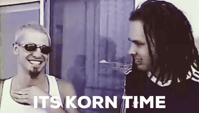 Two Men Are Standing Next To Each Other With The Words " It 'S Korn Time " Written Above Them GIF
