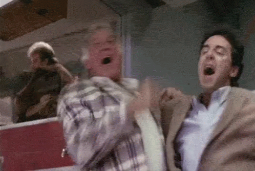 Two Men Are Standing Next To Each Other With Their Mouths Open In A Room . GIF