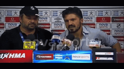 Two Men Are Talking In Front Of A Nova Sports Banner GIF
