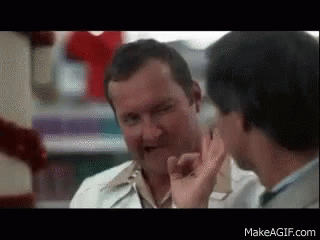 Two Men Are Talking To Each Other In A Pharmacy And One Of Them Is Giving A Thumbs Up . GIF