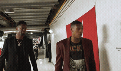 Two Men Are Walking Down A Hallway With A Sign That Says Bulls Staff Only On It GIF