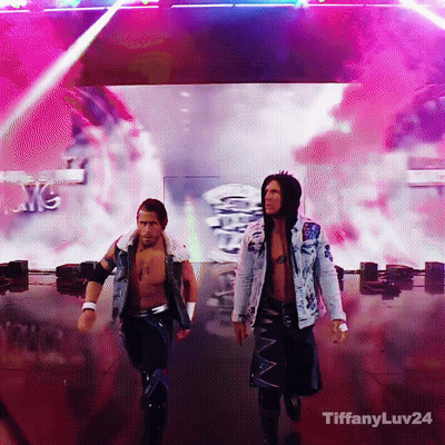 Two Men Are Walking On A Stage With Tiffanyluv24 On The Bottom Right GIF