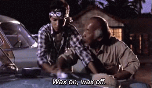 Two Men Are Waxing A Car Together And One Of Them Is Saying `` Wax On , Wax Off . '' GIF