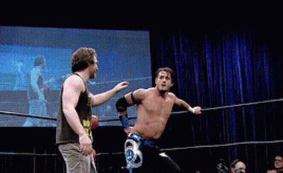 Two Men Are Wrestling In A Ring And One Has A Belt That Says ' A ' On It GIF