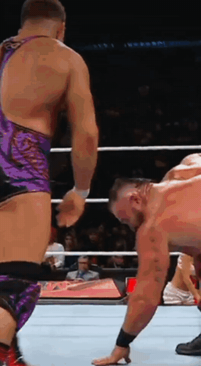 Two Men Are Wrestling In A Ring And One Has His Hand On The Floor GIF