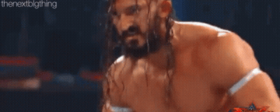 Two Men Are Wrestling In A Ring And One Of Them Is Jumping In The Air GIF
