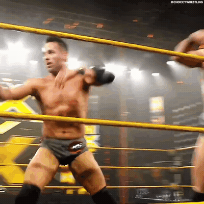 Two Men Are Wrestling In A Ring And One Of Them Is Wearing Shorts That Say Ncs GIF