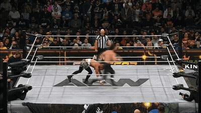 Two Men Are Wrestling In A Ring That Has A Kin Logo On The Floor GIF