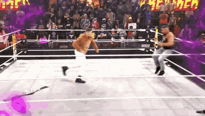 Two Men Are Wrestling In A Ring With A Crowd In The Background GIF
