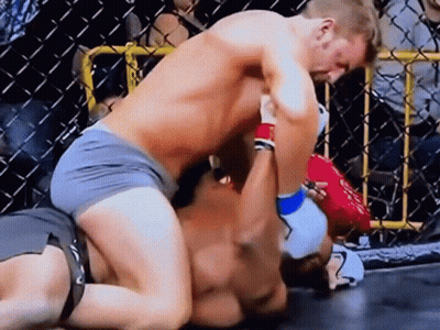 Two Men Are Wrestling In A Ring With A Crowd Watching . GIF