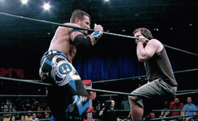 Two Men Are Wrestling In A Ring With One Wearing A Pair Of Shorts That Say J.j. GIF