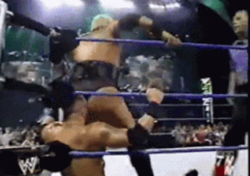 Two Men Are Wrestling In A Ring With The Letters Ww On The Ropes GIF