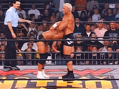 Two Men Are Wrestling In A Ring With The Word Nitro On The Floor GIF