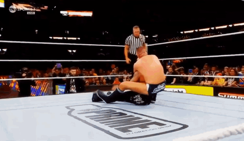 Two Men Are Wrestling In A Ring With The Word Prime On The Floor . GIF