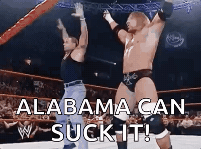 Two Men Are Wrestling In A Ring With The Words Alabama Can Suck It On The Bottom . GIF