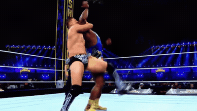 Two Men Are Wrestling In A Wrestling Ring And One Is Kicking The Other . GIF