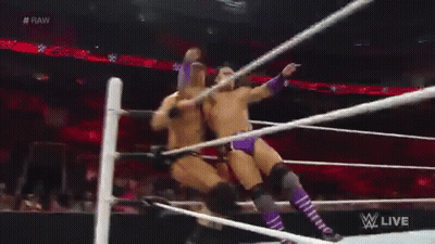 Two Men Are Wrestling In A Wrestling Ring And One Of Them Is Holding A Rope . GIF
