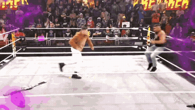 Two Men Are Wrestling In A Wrestling Ring With A Crowd Watching GIF