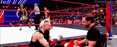 Two Men Are Wrestling In A Wrestling Ring With A Referee Watching . GIF
