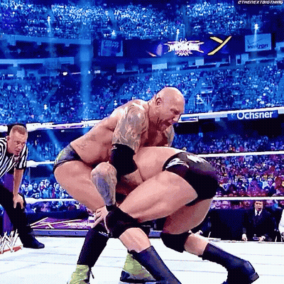 Two Men Are Wrestling In A Wrestling Ring With A Sign That Says Ochsner On It GIF