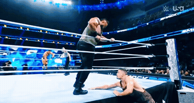 Two Men Are Wrestling In A Wrestling Ring With A Us A Logo In The Background GIF