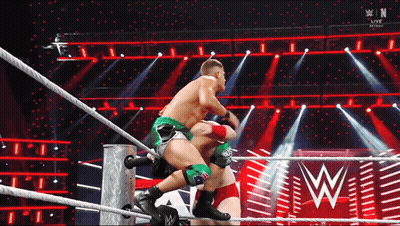 Two Men Are Wrestling In A Wrestling Ring With A W Logo In The Back GIF