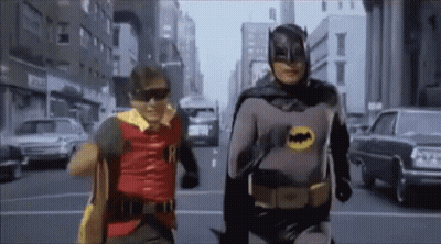 Two Men As Batman And Robin Walking Down Street GIF