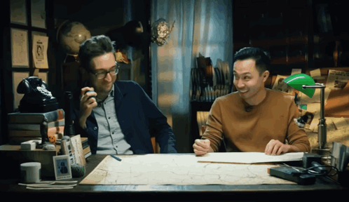 Two Men At Desk With Green Lamp And Map GIF