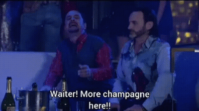 Two Men At Table With Champagne Saying Waiter More Champagne Here GIF