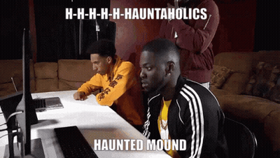 Two Men At Table With Haunted Mound Meme On Laptop GIF