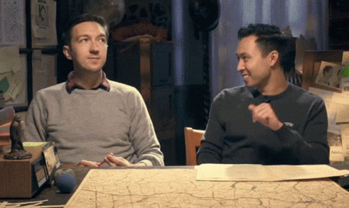 Two Men At Table With Map One Pointing GIF