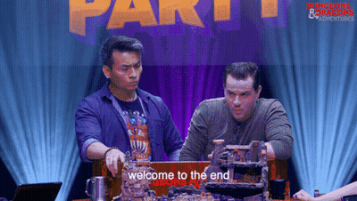 Two Men At Table With Welcome To The End Sign GIF