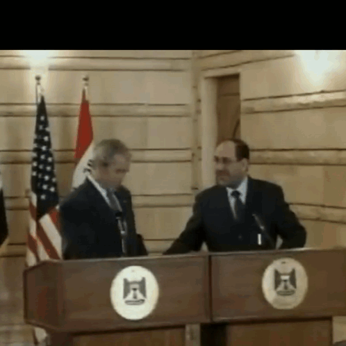 Two Men Behind F Circle Podium GIF